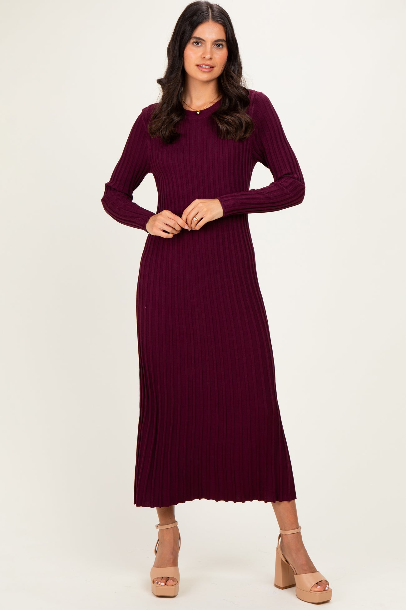 woman wearing a burgundy ribbed long sleeve midi dress with a fitted silhouette and scoop neckline