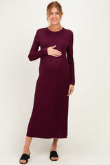 woman wearing a burgundy long sleeve ribbed maternity dress and holding her baby bump