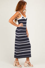 woman wearing a navy and white striped maxi dress with adjustable spaghetti straps and a fitted silhouette