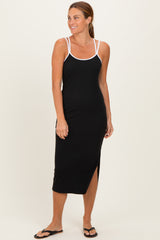 woman wearing a black spaghetti strap maxi dress with white trim and a side slit, standing and smiling