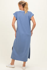 woman wearing a relaxed fit blue maxi maternity dress with short sleeves and side slits, showing her back