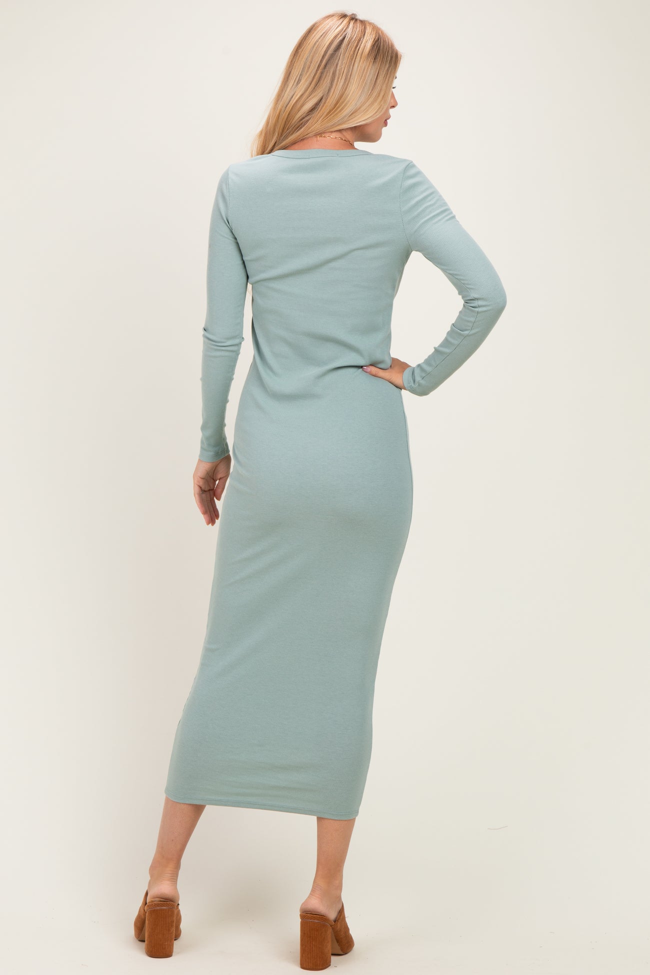 woman wearing a light green long sleeve maxi dress, shown from the back with a form-fitting silhouette