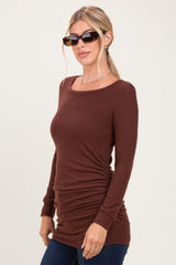 woman wearing a brown long sleeve top with side ruching and sunglasses, paired with dark blue jeans