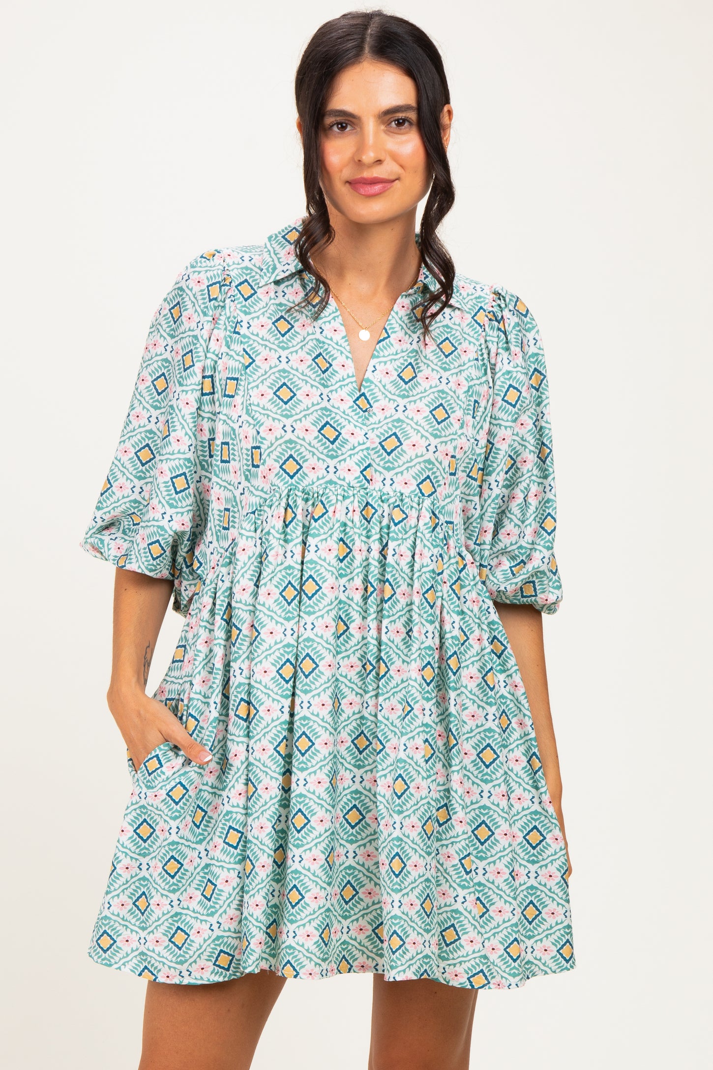 woman wearing a colorful printed short sleeve dress with a v-neck and pockets