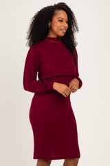 woman wearing a burgundy ribbed long sleeve dress with a fitted silhouette and mock neck