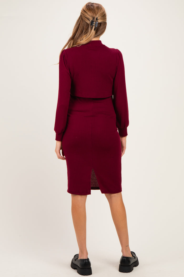 woman wearing a burgundy ribbed maternity dress with a back slit and long sleeves