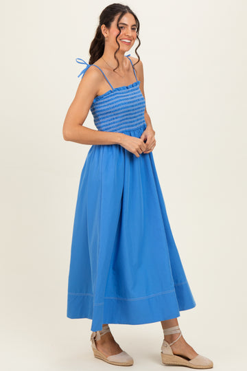 woman wearing a bright blue smocked maxi dress with spaghetti straps and espadrille wedges