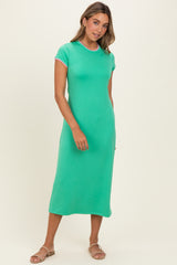 woman wearing a green short sleeve midi dress with contrast neckline and sandals