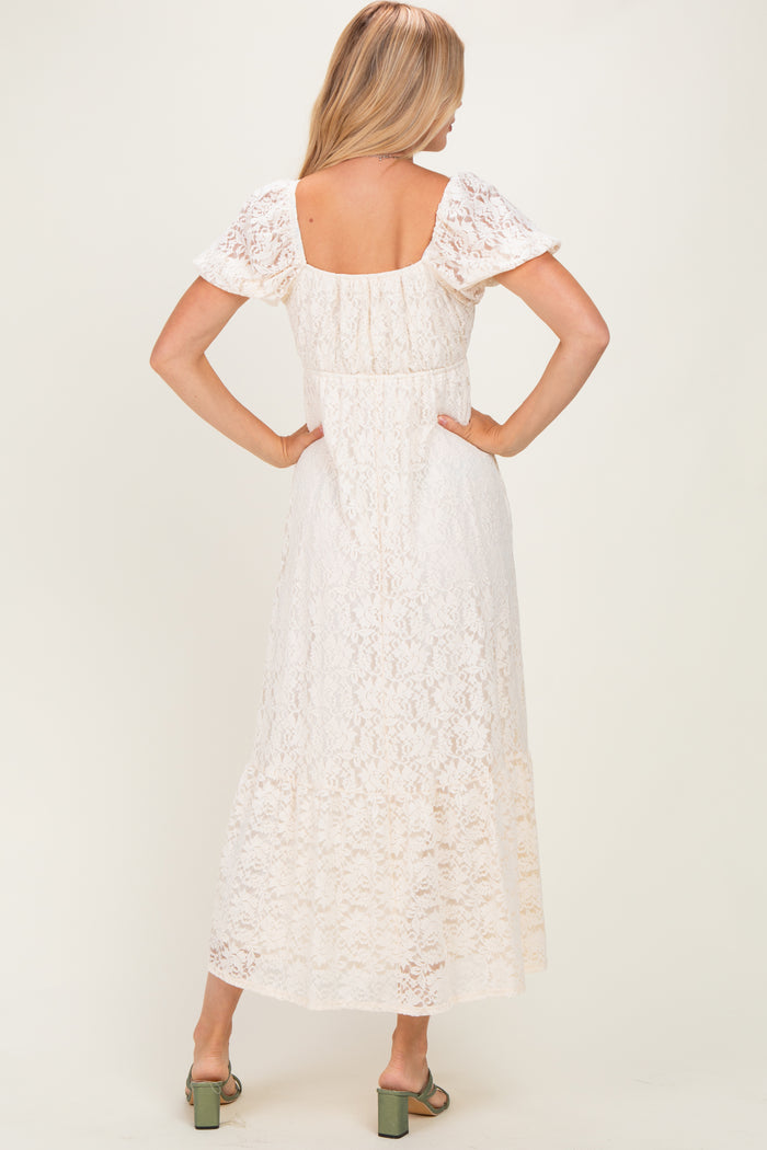 woman wearing a white lace maxi dress with short puff sleeves and a square back, seen from the back