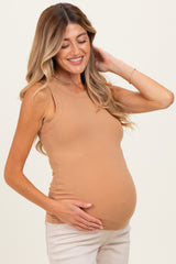 woman wearing a tan ribbed maternity tank top and holding her baby bump