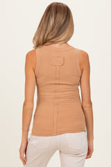 woman wearing a tan sleeveless maternity top with a back seam detail and styled with light-colored pants