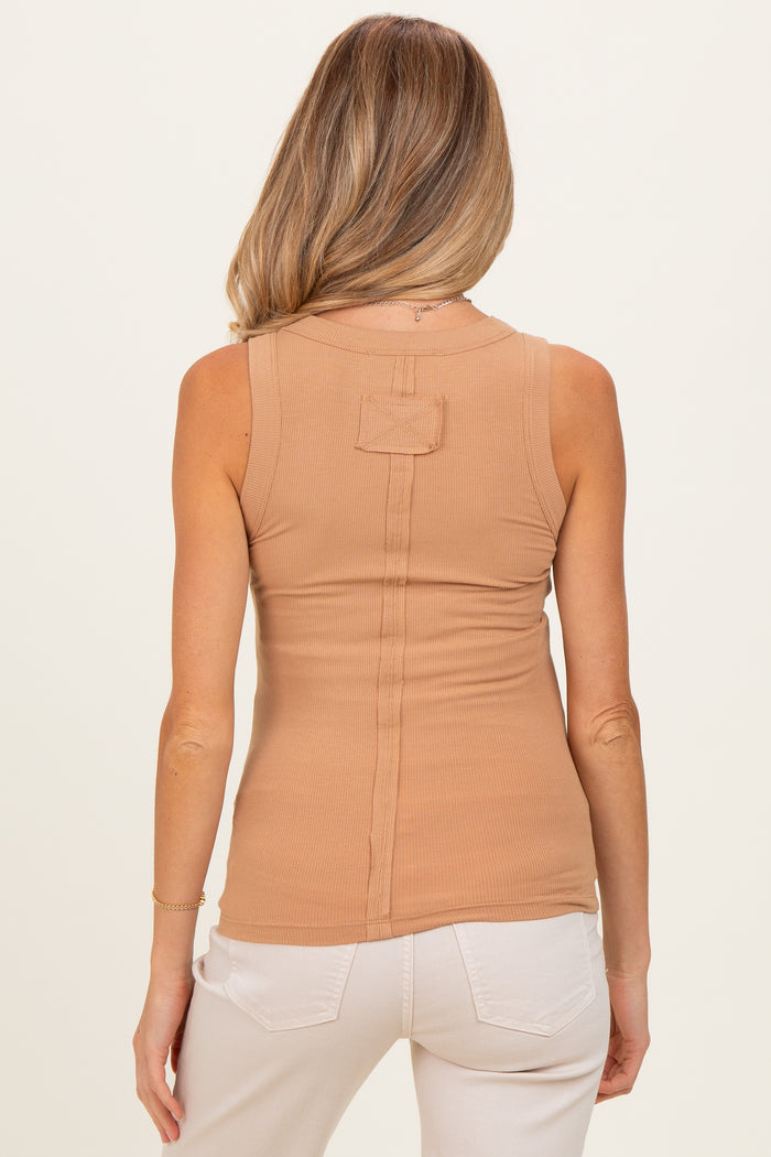 woman wearing a tan sleeveless maternity top with a back seam detail and styled with light-colored pants