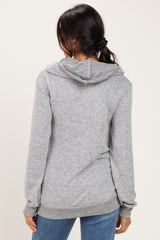 woman wearing a gray cozy hoodie with a relaxed fit and long sleeves, seen from the back