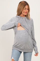 woman wearing a gray maternity hoodie with a front opening for easy access and showing her baby bump