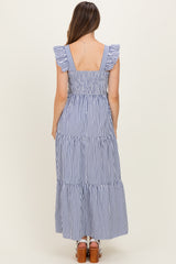 woman wearing a navy and white striped maternity maxi dress with ruffle straps and a tiered skirt