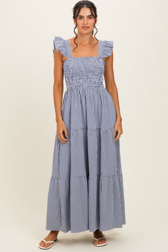 woman wearing a blue and white gingham maxi dress with ruffled shoulder straps and tiered skirt