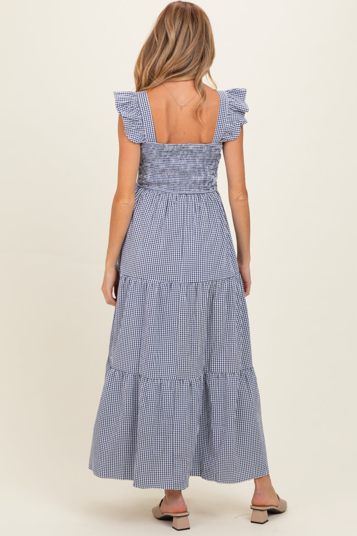 woman wearing a navy and white gingham maternity maxi dress with ruffled sleeves and a tiered skirt, seen from the back