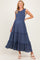 woman wearing a navy blue maternity dress with smocked bodice and tiered ruffled skirt, showcasing her baby bump