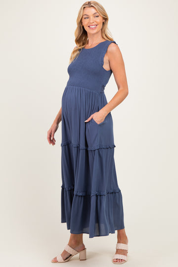 woman wearing a navy blue maternity maxi dress with ruffle tiers and pockets, showcasing her baby bump