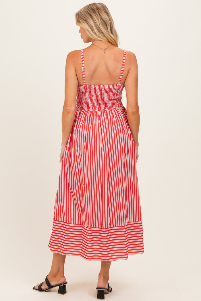 woman wearing a red and white striped maternity dress with a smocked back and midi length in a casual style
