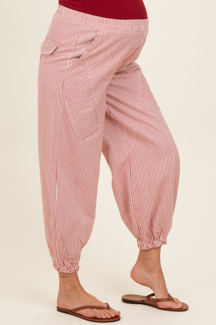 woman wearing red and white striped maternity harem pants with elastic cuffs and side pockets, showing a baby bump