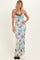 woman wearing a floral print maxi dress in pastel colors with a cowl neckline and lace trim details