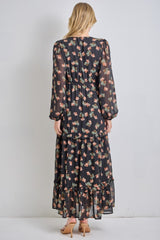 woman wearing a black floral maxi dress with long sleeves and tiered ruffles