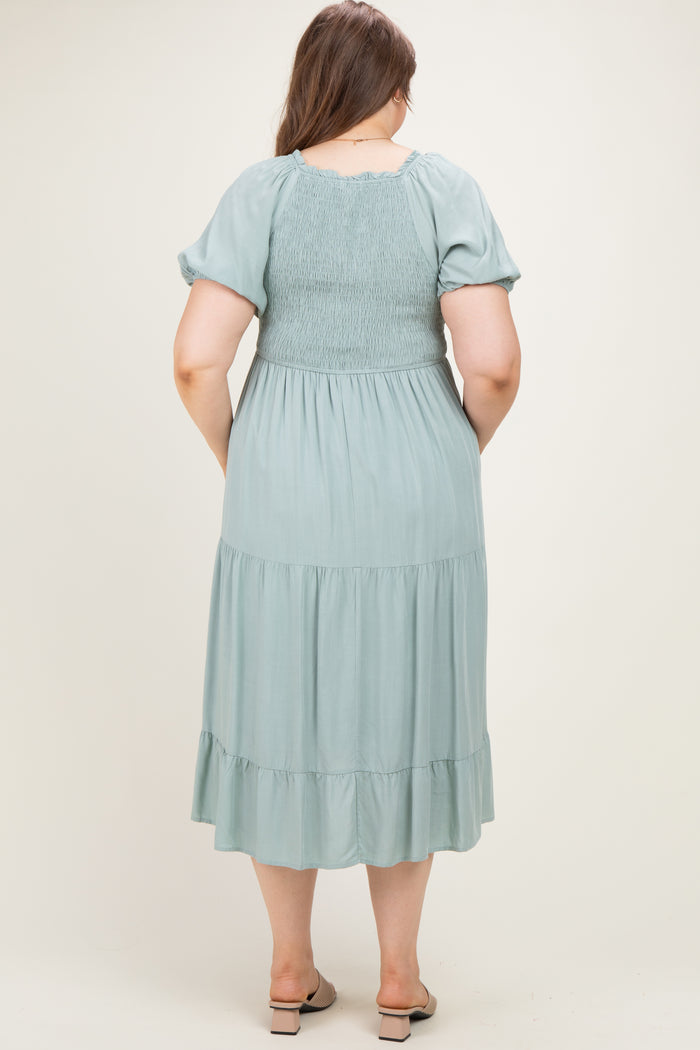 woman wearing a sage green maternity plus maxi dress with smocked bodice and tiered skirt, seen from the back