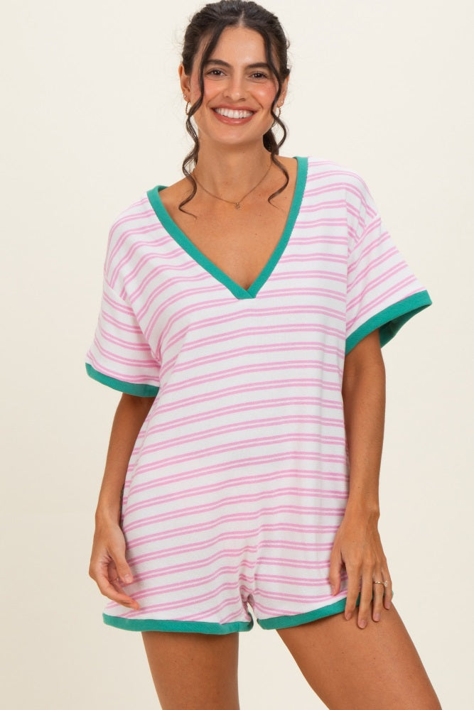 woman wearing a pink and white striped short romper with green trim and a v-neckline
