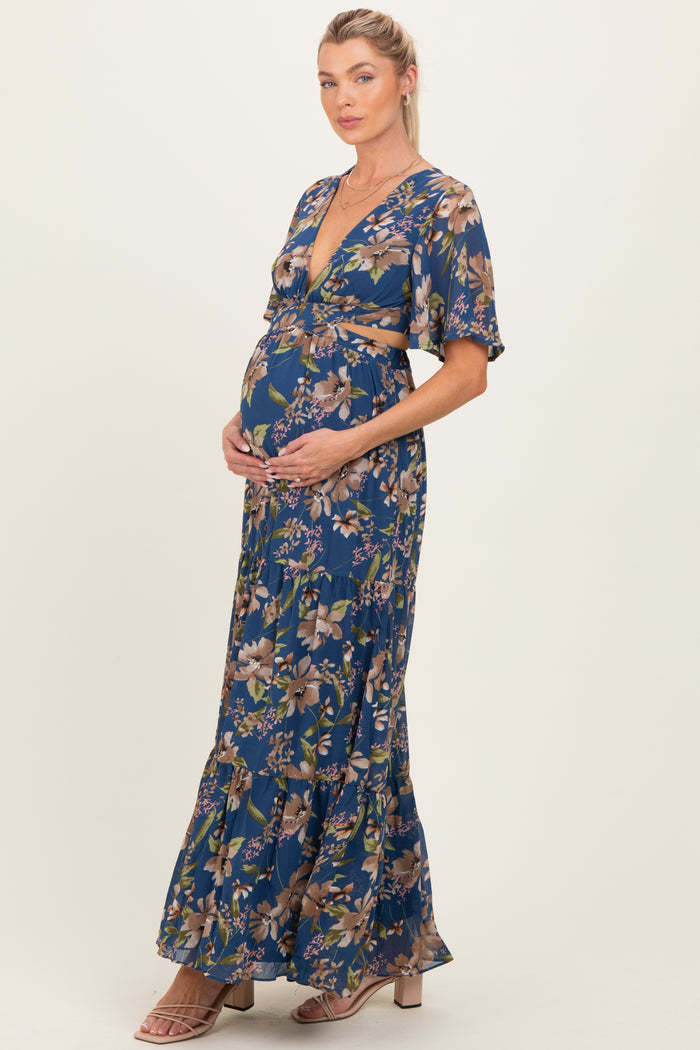 woman wearing a navy blue floral maternity maxi dress and holding her baby bump