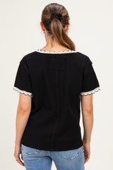 woman wearing a black maternity top with lace trim on sleeves, seen from the back