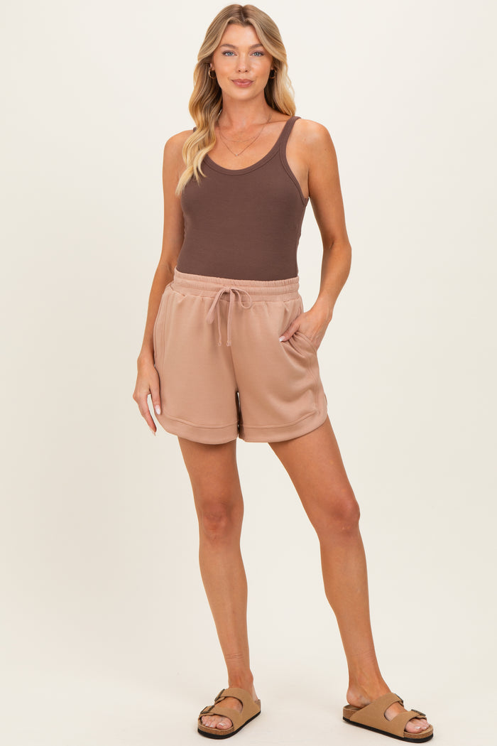 woman wearing a brown tank top and beige maternity shorts with a drawstring and pockets