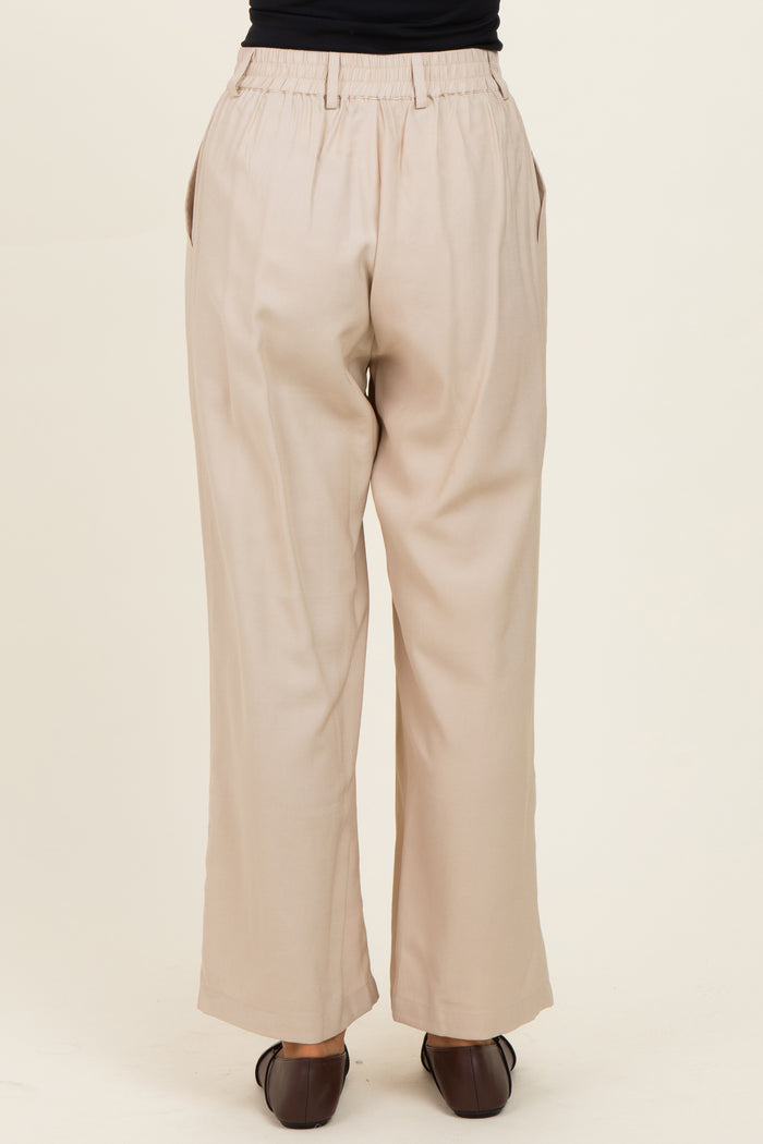 woman wearing beige wide-leg trousers, showing the back view and elastic waistband