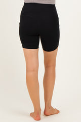 woman wearing black maternity shorts, shown from the back, featuring a high waistband and side pockets