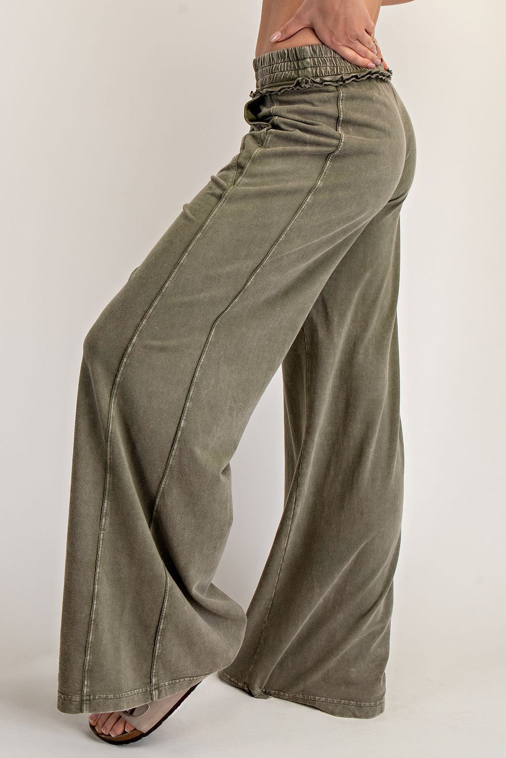 woman wearing olive green wide-leg pants with an elastic waistband and subtle side seam details