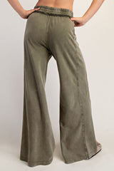 woman wearing olive green wide leg pants with an elastic waistband and a relaxed fit