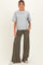 woman wearing a grey maternity t-shirt and olive green wide leg pants, standing with hands in pockets