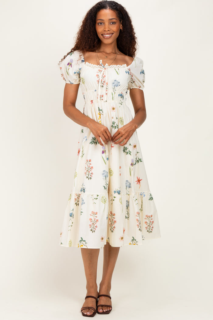 woman wearing a white floral midi dress with puff sleeves and a smocked bodice, standing with hands at her sides