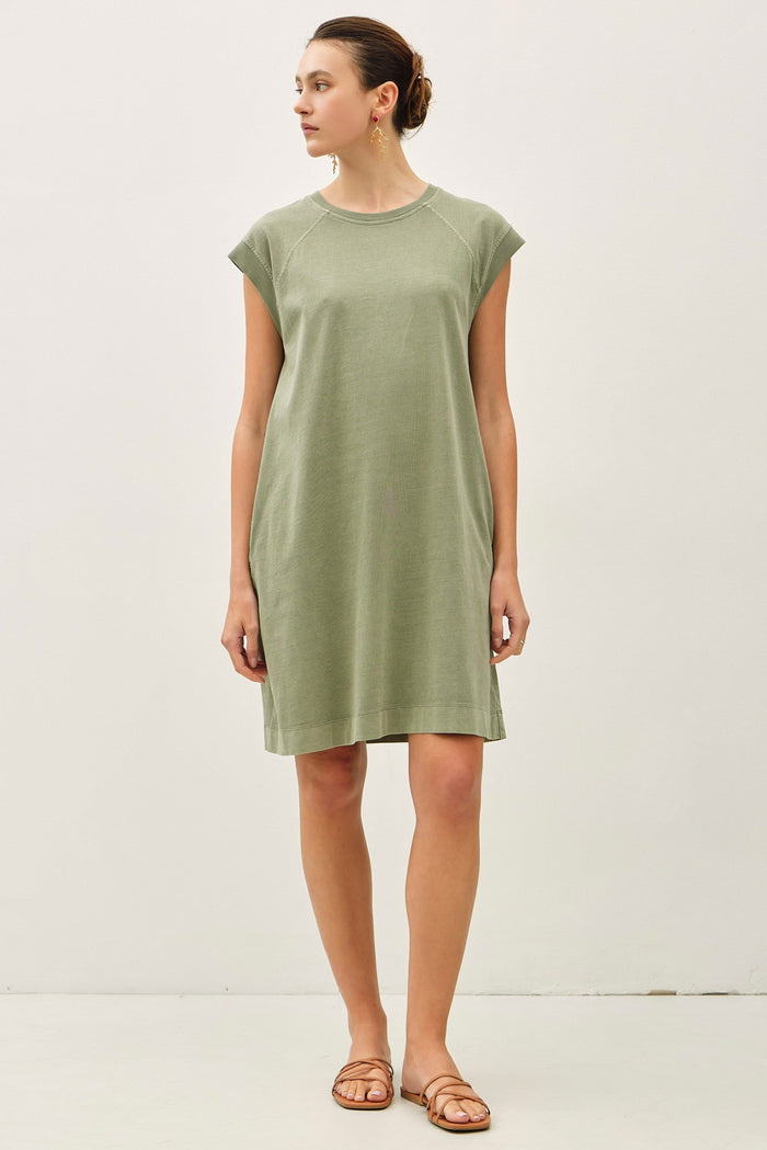 woman wearing a relaxed fit olive green cap sleeve dress with a round neckline and side pockets