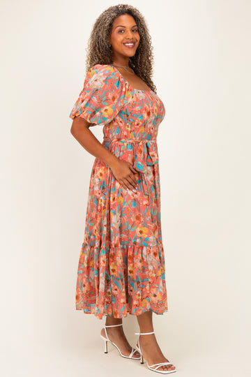 woman wearing a colorful floral plus size midi dress with puff sleeves and a cinched waist, smiling