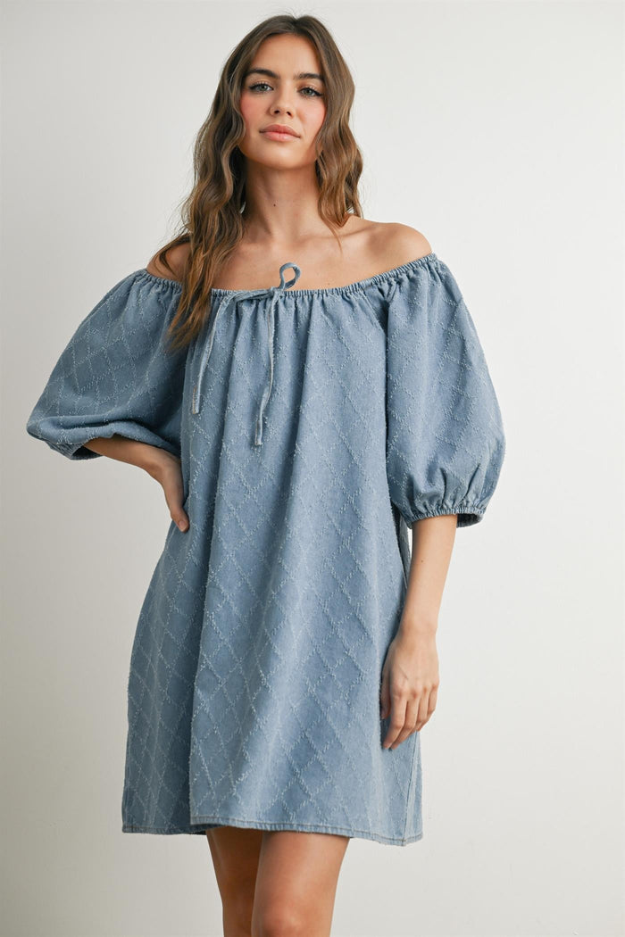 woman wearing a light blue off-the-shoulder denim dress with puff sleeves and a drawstring detail