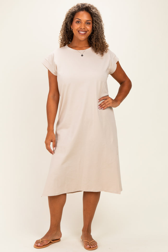 woman wearing a beige short sleeve plus size dress, standing with hands on hips and smiling at the camera