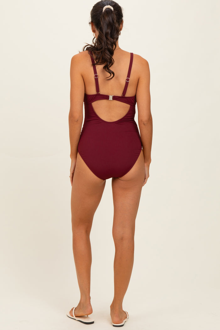 woman wearing a burgundy ribbed one-piece swimsuit with adjustable straps and a cutout back design