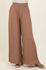 woman wearing loose-fitting mauve wide-leg pants with a smocked waistband