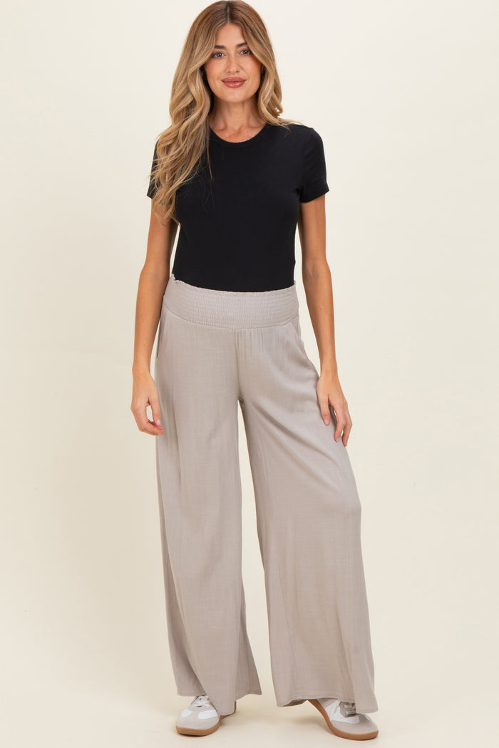 woman wearing a black short sleeve shirt and gray wide-leg maternity pants with a comfortable waistband
