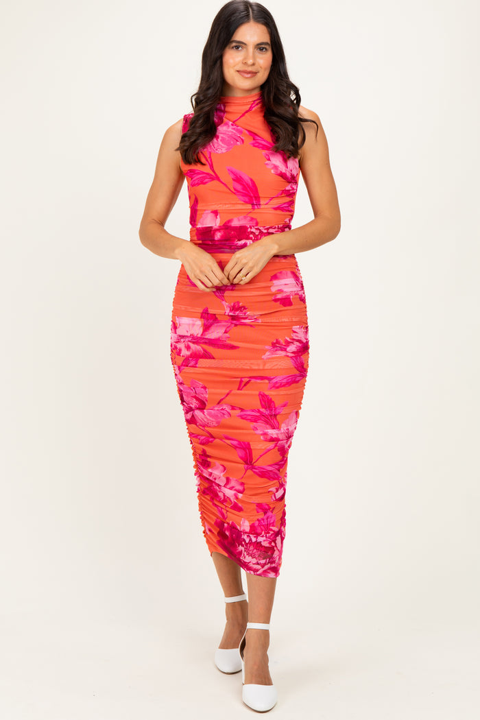 woman wearing a vibrant pink floral midi dress with a fitted silhouette and high neckline