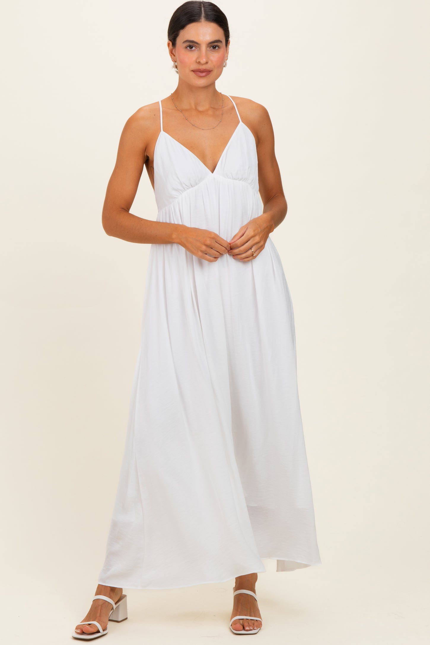 woman wearing a white maxi dress with thin straps and a flowing silhouette