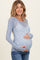 woman wearing a light blue sheer maternity top with floral patterns and a visible baby bump