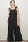 woman wearing a black sleeveless jumpsuit with ruffle details and wide legs