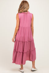 woman wearing a pink sleeveless tiered maternity dress with a flowy silhouette, showing the back view